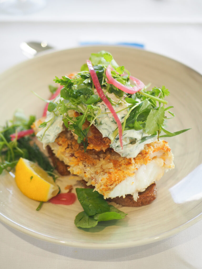 Smørrebrød met krokant gebakken zeebaars, groene remoulade en kruiden